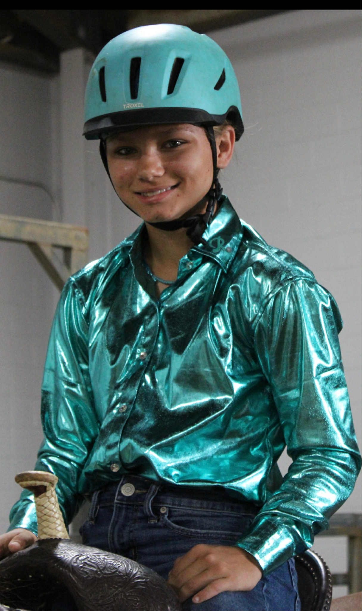 Youth in a shiny turquoise Island Time barrel racing show shirt with a matching helmet