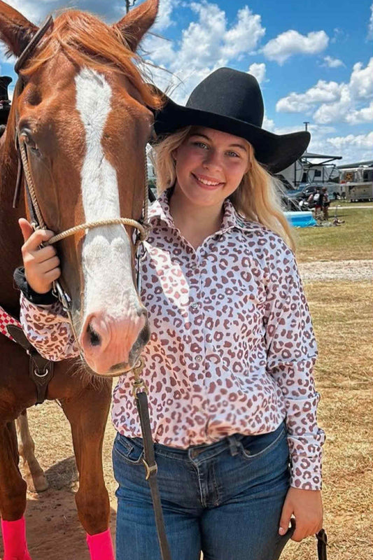 Wild Run Leopard barrel racing show shirt with pink and brown leopard print on white, button-down closure, and long sleeves, styled with jeans and cowboy hat.