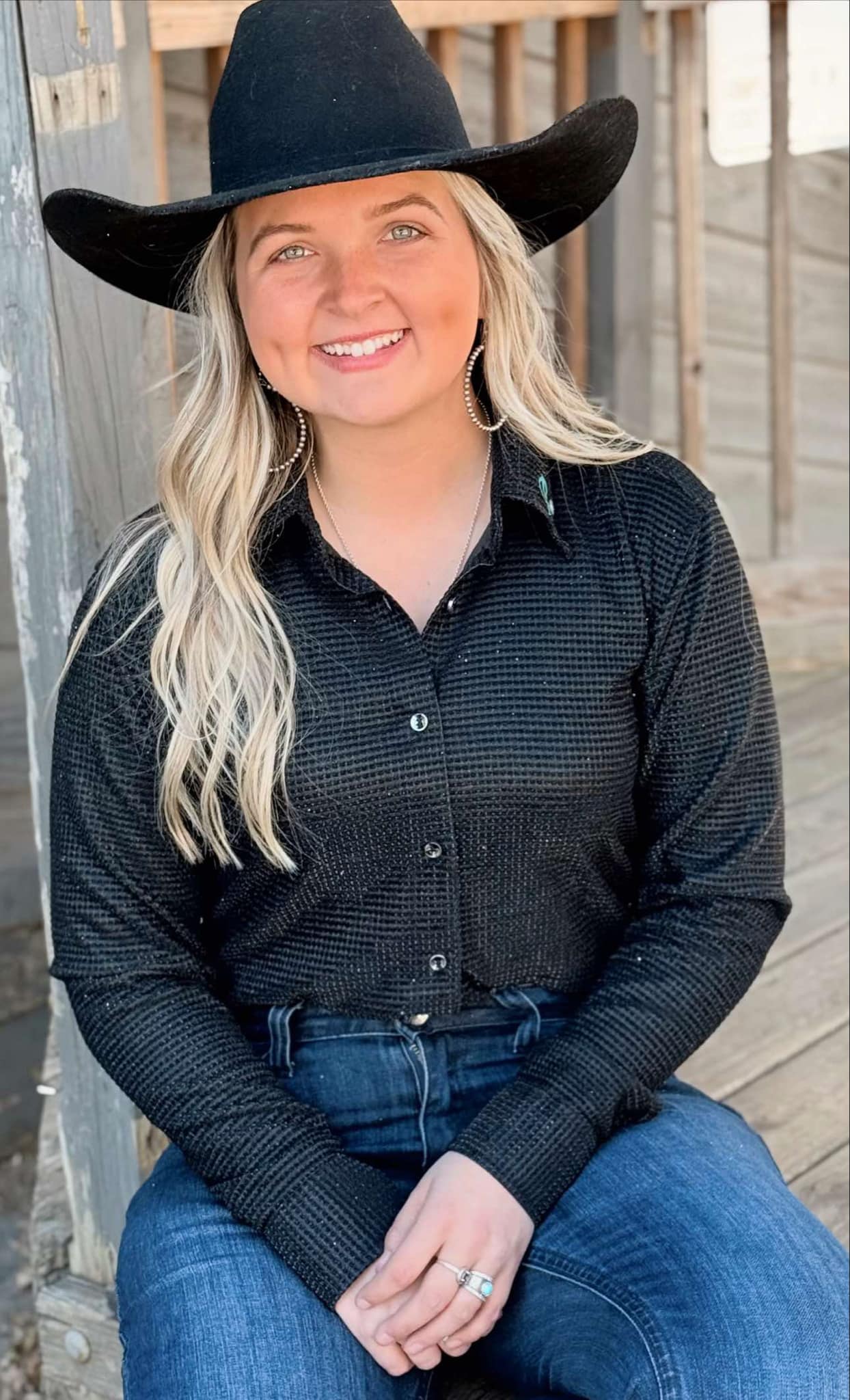 Black textured barrel racing shirt with sparkles, button-down front, worn by a model with cowboy hat, showcasing western style.