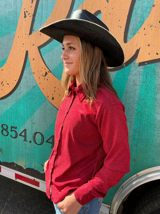 Model is wearing a black cowgirl hat and a red rodeo shirt.